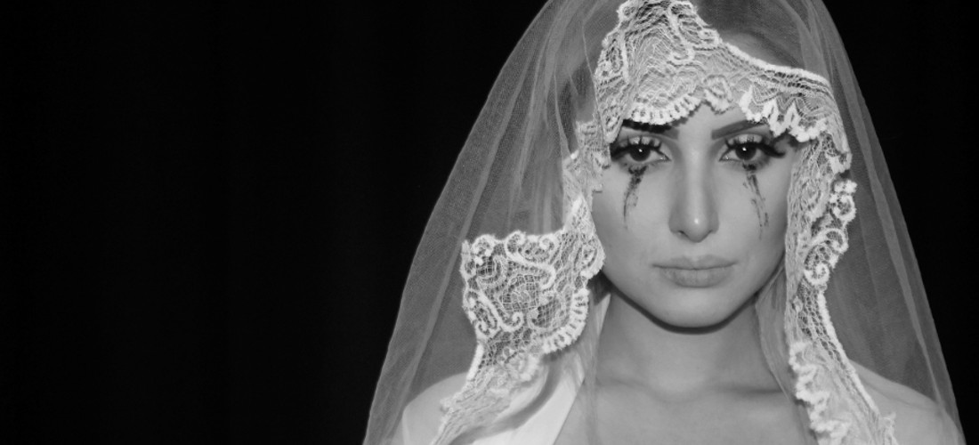 Eine weinende Braut vor schwarzen Hintergrund.