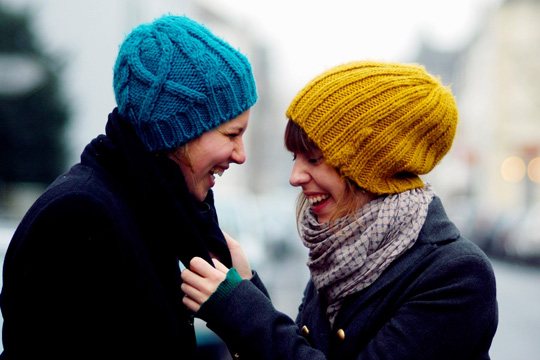 Das Foto zeigt zwei junge Frauen, die miteinander lachen. 