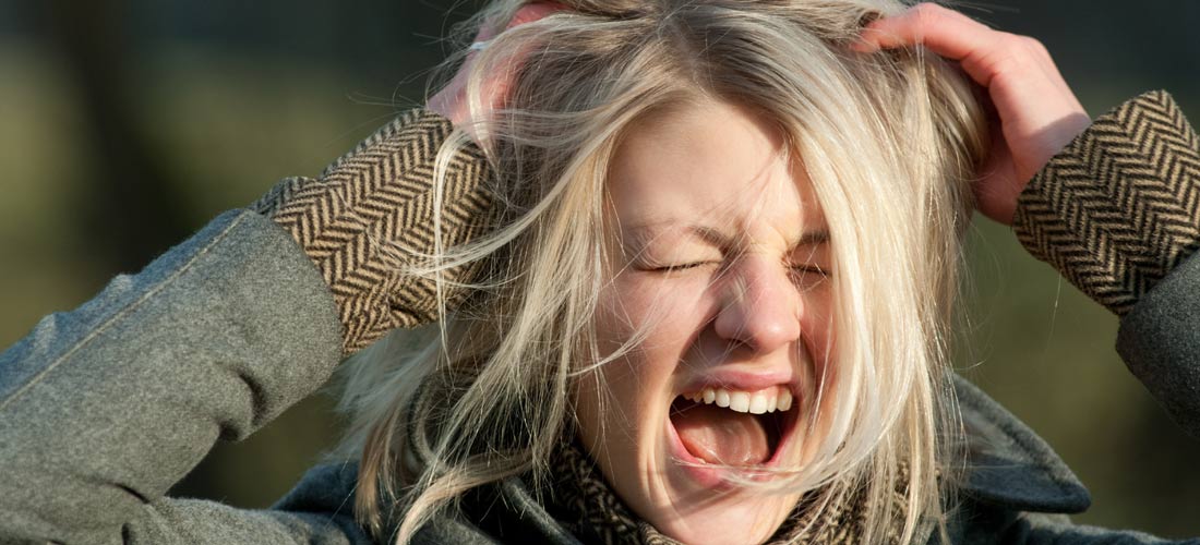 Das Foto zeigt ein Mädchen, das sich in die Haare greift und schreit. Ihre Augen sind zugekniffen.