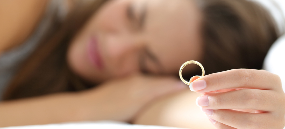 Das Foto zeigt ein Mädchen (unscharf im Hintergrund), das einen Ring in die Kamera hält. Ihr Blick ist nachdenklich nach unten gerichtet. Das Foto zeigt ein Mädchen (unscharf im Hintergrund), das einen Ring in die Kamera hält. Ihr Blick ist nachdenklich nach unten gerichtet.